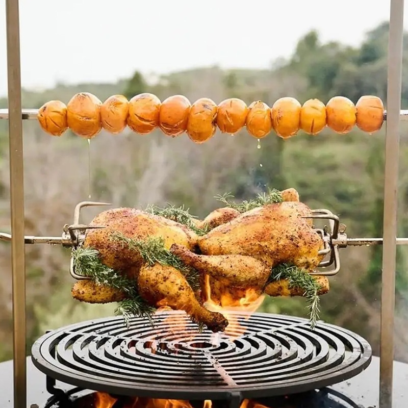 Poulets rôtis à la broche avec romarin et pommes de terre grillées sur un barbecue en plein air.