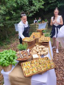 Buffet traiteur champêtre avec assortiment d'amuse-bouches variés lors d'une réception en forêt.