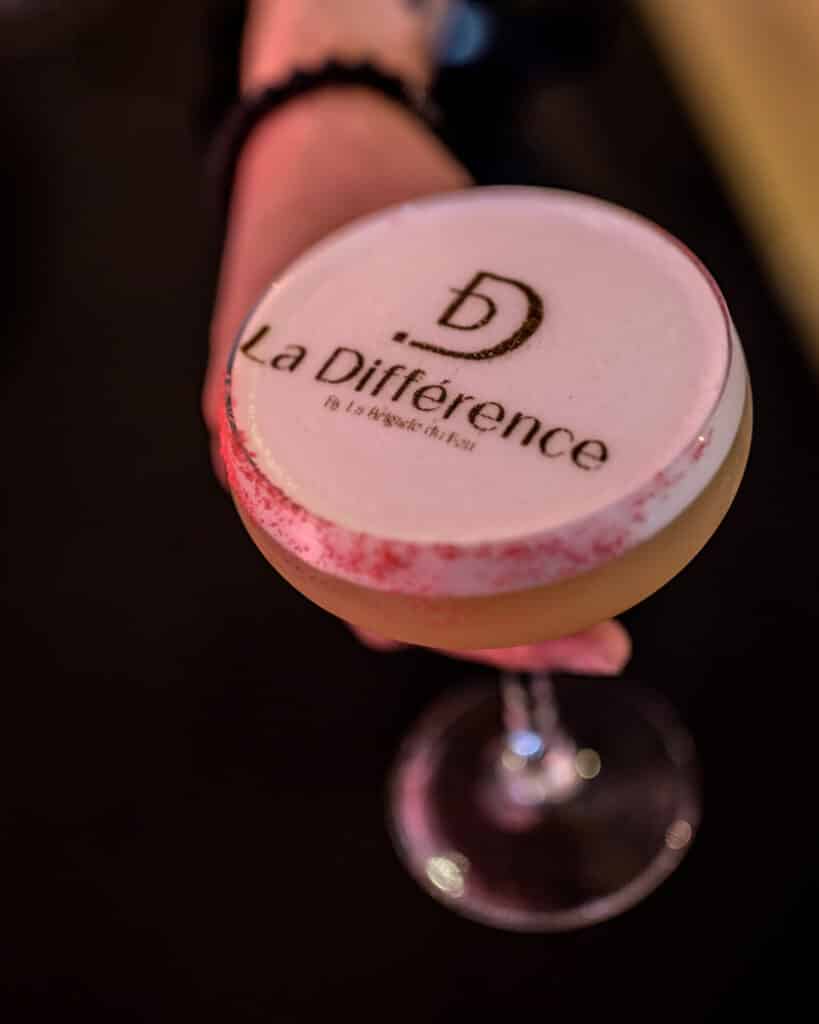 Cocktail Signature La Différence par La Brigade du Feu Cocktail La Différence par La Brigade du Feu avec logo imprimé sur mousse et rebord rose délicat.